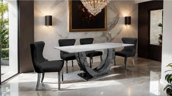 Primenova Upholstered Silver Black Dining Chair A modern dining room set featuring a rectangular white marble-top table with a sculptural curved dark gray stone base, surrounded by four black upholstered dining chairs with silver metal legs.