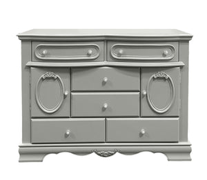 Primrose Gray Dresser with Floral Accent A classic-style gray wooden dresser with ornate carved details, oval cabinet doors, and multiple drawers, shown against a plain white background.