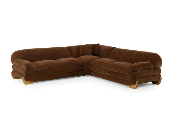 Prinkett Modular Corner Brown Fabric Sectional Sofa A brown velvet sectional sofa with a curved, low-profile design and light wood legs, shown from a three-quarters angle on a white background.