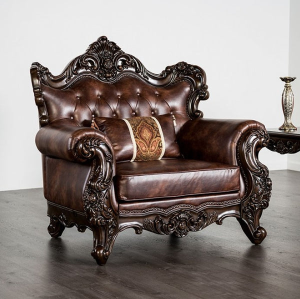Prisya Traditional Leatherette Rolled Arm Chair Decorative brown leather sofa with intricate carvings in a room.
