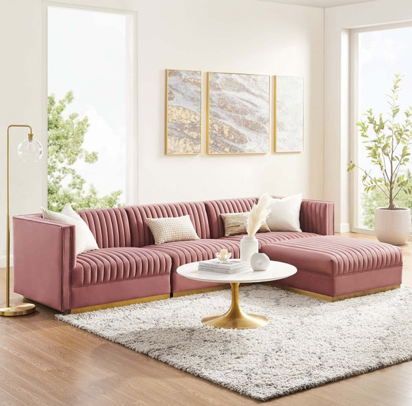 Sanchi 4PC Channel Tufted Velvet Modular Sectional Sofa Rose Pink sectional sofa in a living room with a white coffee table and decorative elements.