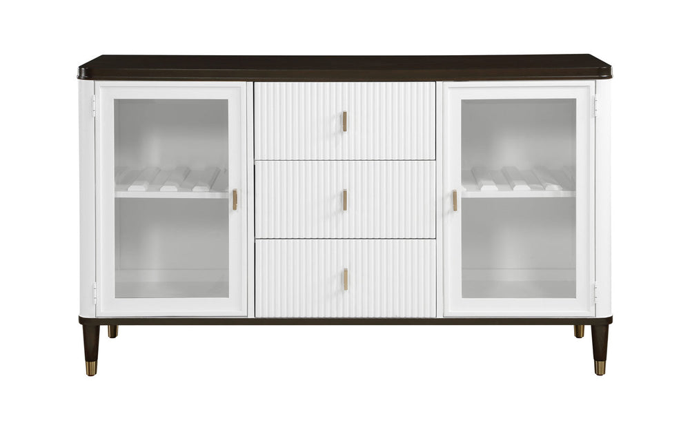 Serania Two Tone Dining Server A modern white sideboard cabinet with a dark brown top, glass-front doors on both sides, and three ribbed center drawers with small gold handles, shown against a light gray wall and wood floor.