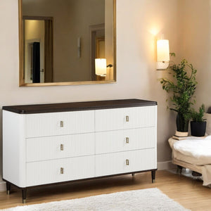 Serania Two Tone Dresser White dresser with black top in a room with a mirror, lamp, and plants.