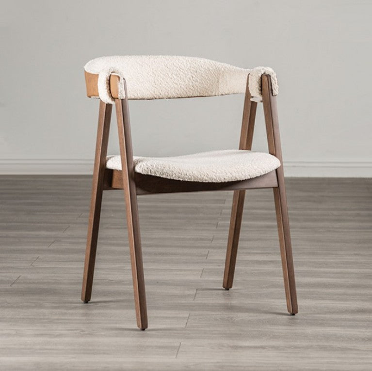 Serika Mid Century Modern Walnut Dining Chair A modern wooden dining chair with a cream bouclé upholstered seat and curved backrest, set against a neutral gray wall and light gray wood-look floor.