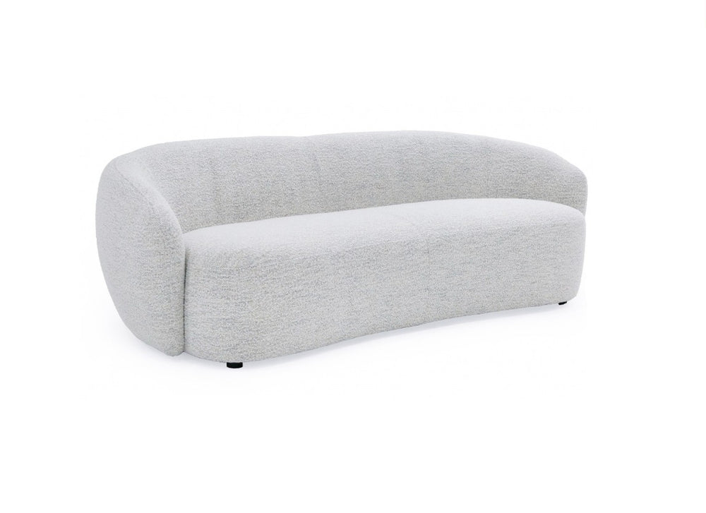 Silvi Off White Modern Fabric Sofa Modern beige sofa in a minimalistic living room with a large window.