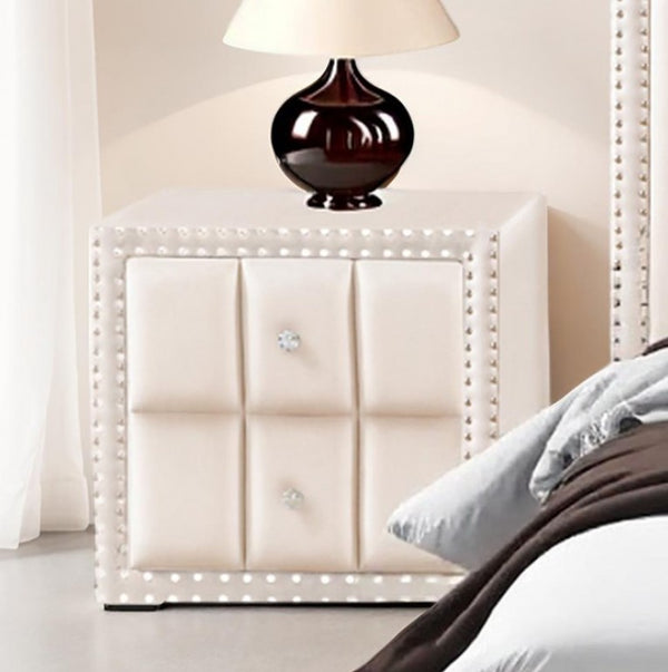 Sluvender Modular Upholstered Nightstand Beige Finish White upholstered headboard with decorative nailhead trim and a lamp in a bedroom setting.