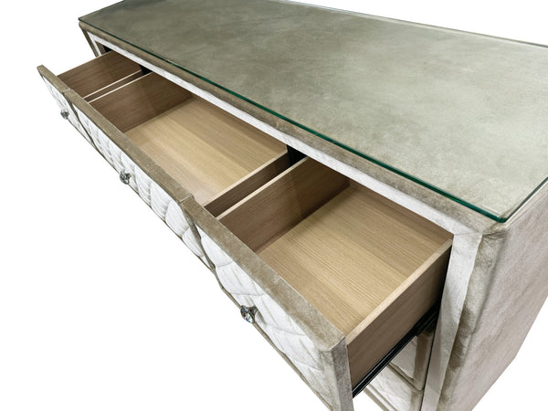 Sonya Beige Velvet Upholstered Traditional Style Dresser A modern console table featuring a textured gray concrete-look top with a clear glass edge, a light wood interior with two open drawers, and a quilted light gray side panel.