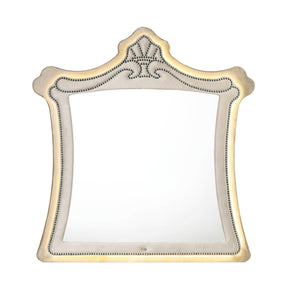 Sonya Beige Velvet Upholstered Traditional Style Mirror An ornate decorative wall mirror with a gold-toned frame featuring a crest at the top and a beaded border around the reflective glass.