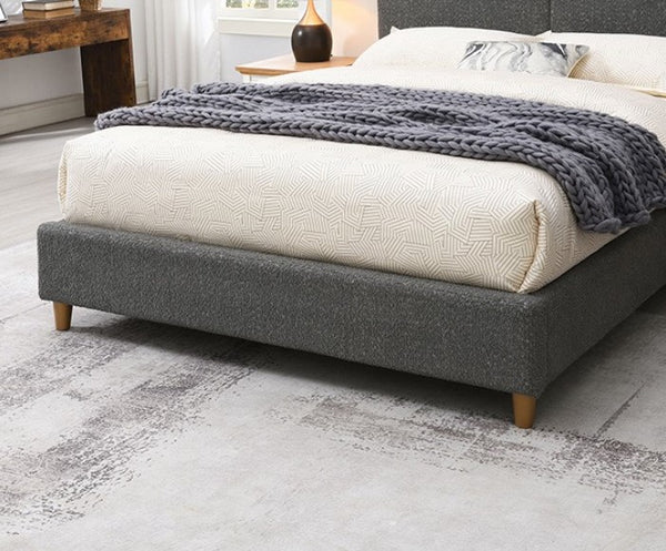 Stivan Bed Fully Upholstered Gray Boucle Fabric Gray upholstered bed with white bedding and a gray blanket in a bedroom setting.
