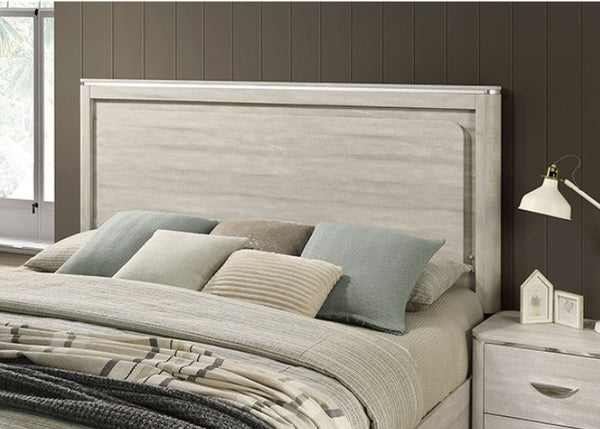 Sundy Curved Edge Dusty Gray Bed Bedroom with a bed featuring pillows and a blanket, next to a nightstand with a lamp.