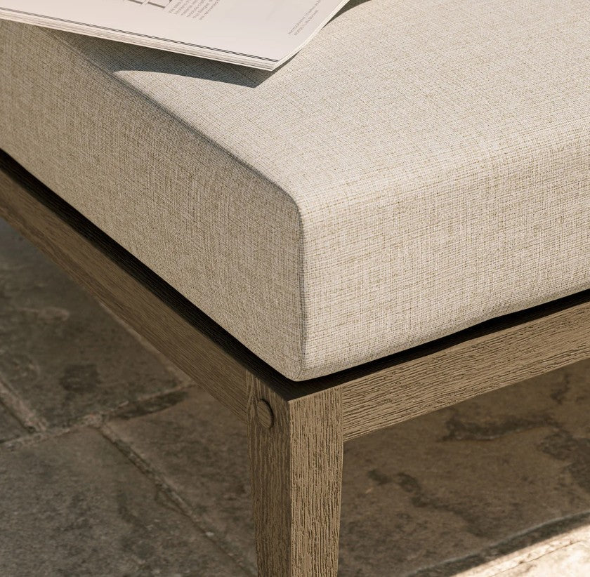 Sunshore Pebble Outdoor Ottoman Outdoor ottoman with cushion on a patio with hydrangeas and ocean view