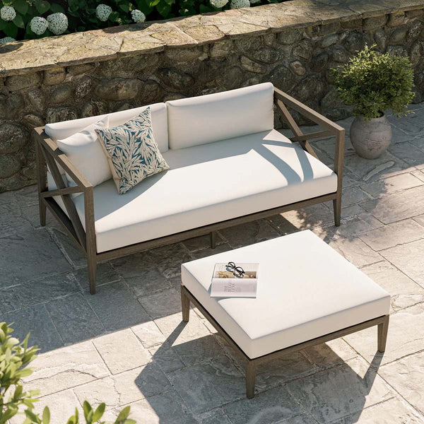 Sunshore Weathered Gray Loveseat and Ottoman Outdoor Set Outdoor patio set with a sofa and coffee table on a stone patio.