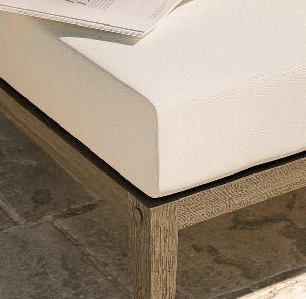 Sunshore Weather Gray Outdoor Ottoman Close-up of a wooden bench with a white cushion on a stone floor.