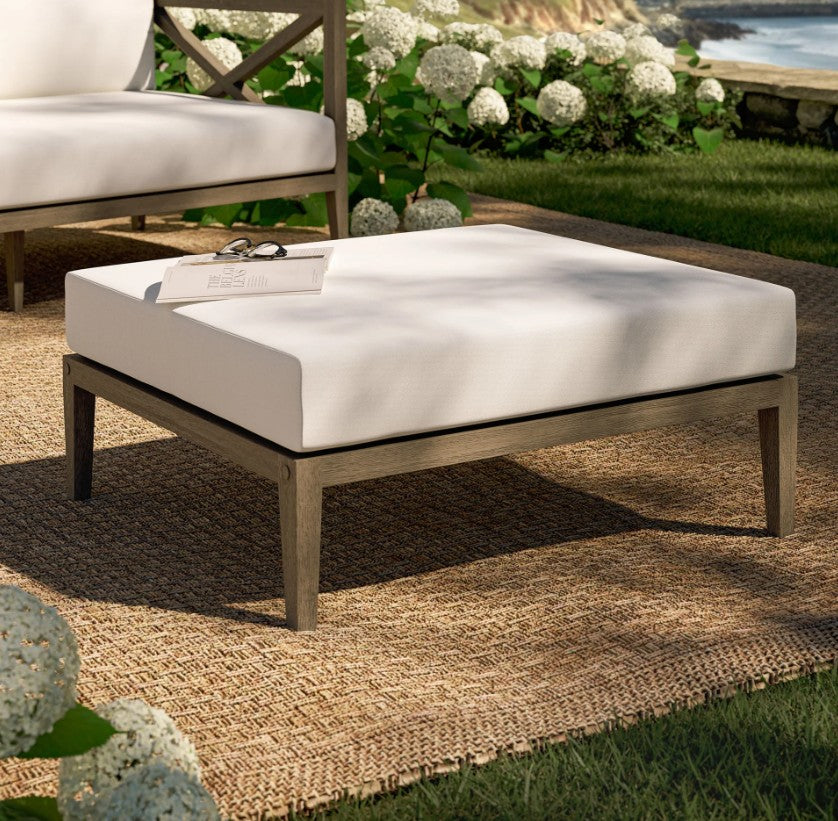 Sunshore Weather Gray Outdoor Ottoman Outdoor patio bench with white cushion on a grassy area with flowers and a chair in the background.