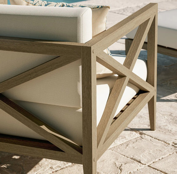 Sunshore Weathered Gray Outdoor Armchair Wooden outdoor table with geometric design on a stone patio