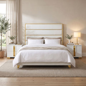 Sysko Glam Gold White Fully Upholstered Bed A modern white upholstered bed with a gold metal frame and headboard, styled in a bright, contemporary bedroom with white bedding, matching nightstands, and a beige rug.
