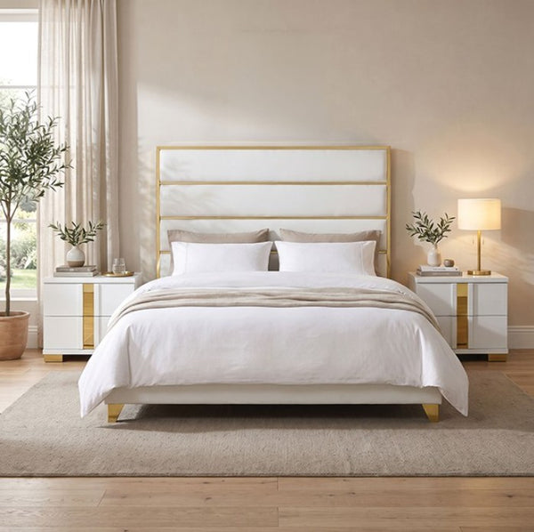 Sysko Glam Gold White Fully Upholstered Bed A modern white upholstered bed with a gold metal frame and headboard, styled in a bright, contemporary bedroom with white bedding, matching nightstands, and a beige rug.