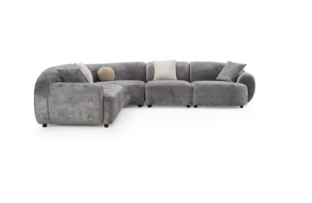 Tiarra Corner Sectional Sofa Fabric Gray A curved modular upholstered sofa in a textured light gray fabric, styled with four neutral throw pillows, shown against a plain white background.