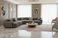 Tiarra Corner Sectional Sofa Fabric Gray A curved modular upholstered sofa in a textured light gray fabric, styled with four neutral throw pillows, shown against a plain white background.