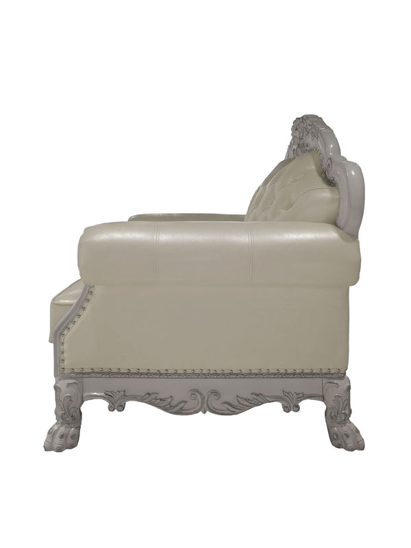 Traditional Style Chair Bone White Dresden Collection An ornate cream-colored leather chaise lounge with a carved light gray wooden frame, featuring a tufted backrest, nailhead trim, and clawfoot legs.