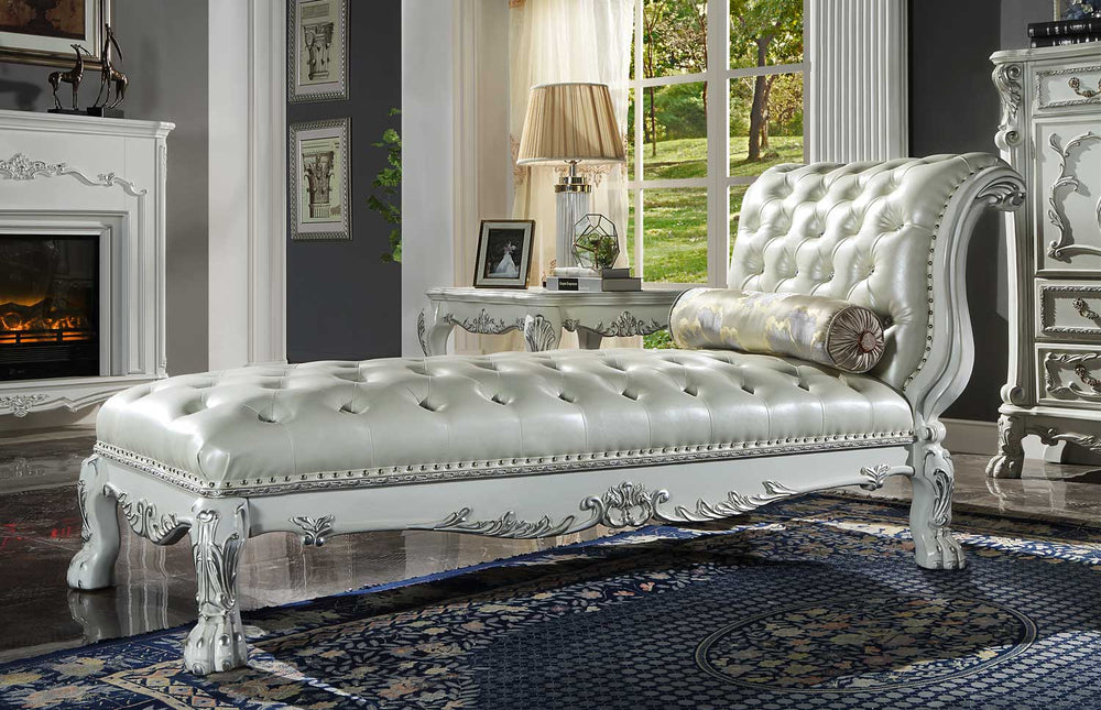 Traditional Style Chaise Bone White Dresden Collection An ornate white tufted chaise lounge chaise lounge chaise lounge chaise lounge with carved silver accents, styled in a classic living room setting with a fireplace, window, and patterned rug.