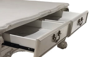 Traditional Style Coffee Table Bone White Dresden Collection A close-up of a white carved wooden chest of drawers with two open drawers, showcasing ornate dark metal handles and drawer slides against a white background.
