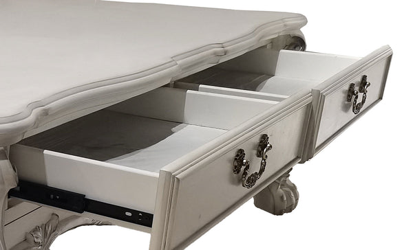 Traditional Style Coffee Table Bone White Dresden Collection A close-up of a white carved wooden chest of drawers with two open drawers, showcasing ornate dark metal handles and drawer slides against a white background.