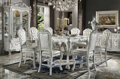 Traditional Style Counter Height Dining Table Bone White Dresden Collection An ornate white carved dining room set with a rectangular table and eight matching upholstered chairs, shown in a luxurious dining room with a crystal chandelier, hutch, and sideboard.