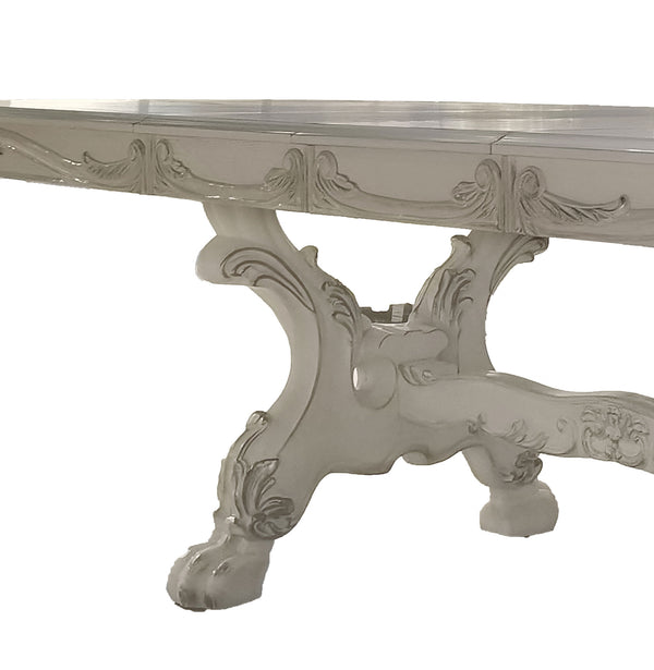 Traditional Style Dining Table Bone White Dresden Collection An ornate white carved console table featuring a glass top and a sculptural baroque-style pedestal base with claw-like legs.