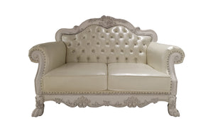 Traditional Style Loveseat Bone White Dresden Collection An ornate cream-colored loveseat sofa with a carved, distressed white frame, featuring tufted button detailing on the backrest and nailhead trim on the arms and base.