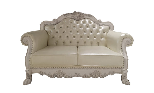 Traditional Style Loveseat Bone White Dresden Collection An ornate cream-colored loveseat sofa with a carved, distressed white frame, featuring tufted button detailing on the backrest and nailhead trim on the arms and base.