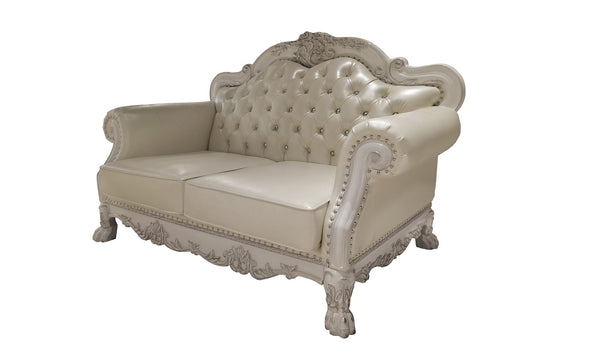 Traditional Style Loveseat Bone White Dresden Collection An ornate cream-colored loveseat sofa with carved wood details, button-tufted upholstery, and nailhead trim, shown against a plain white background.