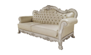 Traditional Style Sofa Bone White Dresden Collection An ornate cream-colored tufted loveseat sofa with distressed white carved wood arms and legs, shown against a plain white background.