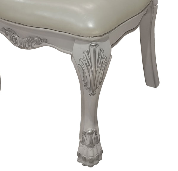 Traditional Style Dining Chair Bone White Dresden Collection Close-up of an ornate vanity stool or bench leg with carved scrollwork and claw-foot styling, featuring a light gray frame and a cream upholstered seat against a white background.