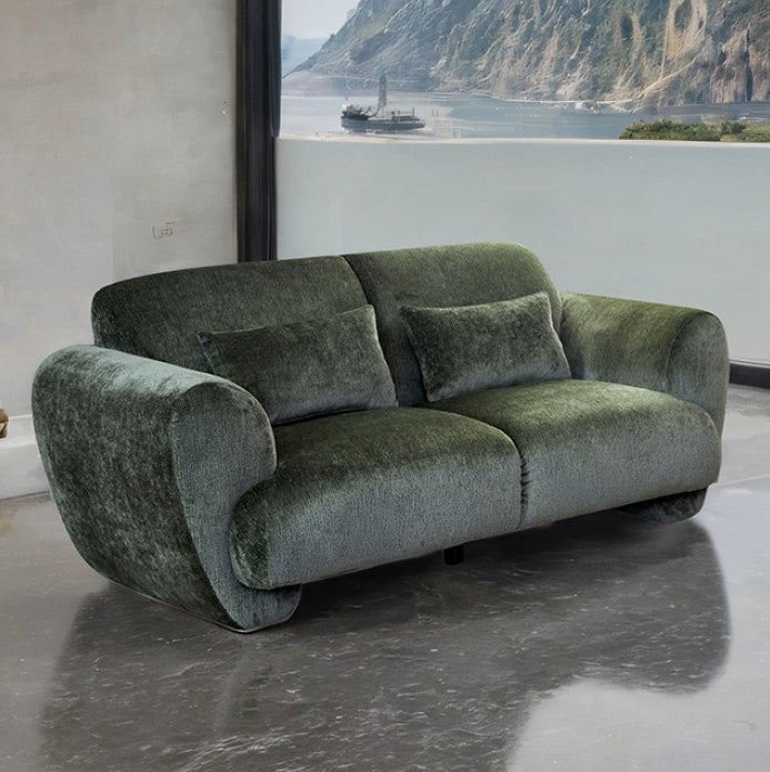 Travus Olive Green Chenille Loveseat Green velvet sofa in a room with a large window showing a mountainous landscape.