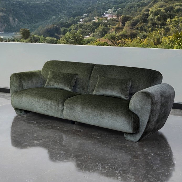Travus Olive Green Chenille Sofa Green sofa on a reflective surface with a scenic background