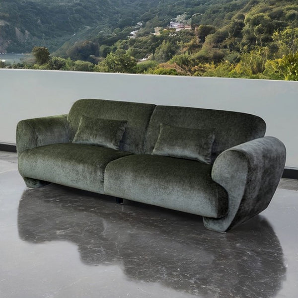 Travus Olive Green Chenille Sofa Green sofa on a reflective surface with a scenic background