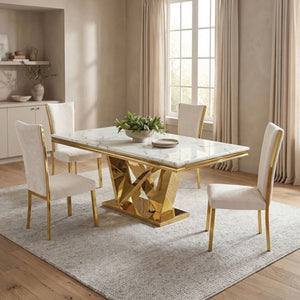 Valdi Gold White Sintered Stone Top Dining Table A modern dining set featuring a rectangular marble-top table with a geometric gold metallic base and four matching cream upholstered chairs with gold legs, styled in a bright, contemporary dining room.
