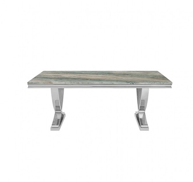 Valdi Silver Gray Sintered Stone Top V-Style Pedestal Dining Table A rectangular dining table with a polished silver chrome base and a gray marble-patterned top, styled in a bright room with a beige rug, wood floors, and a window.