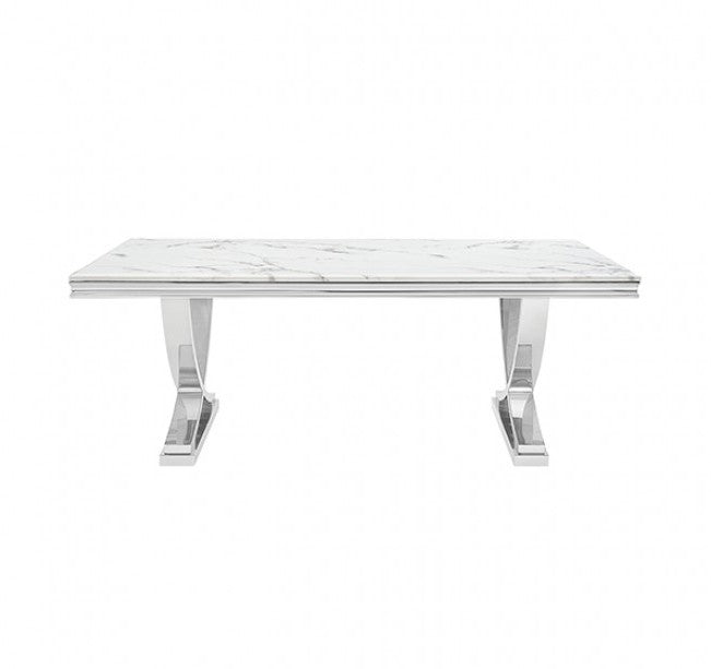 Valdi Silver White Sintered Stone Top V-Style Pedestal Dining Table A rectangular dining table with a white marble-look top and polished silver metal pedestal legs, styled in a bright dining room on a light rug over hardwood floors.