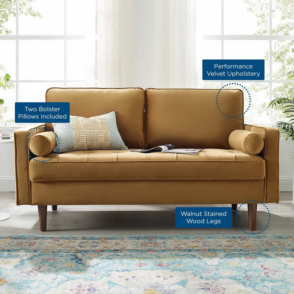 Vaspire Modern Cognac Velvet Performance Loveseat Brown sofa with bolster pillows and wooden legs in a room with large windows and plants.