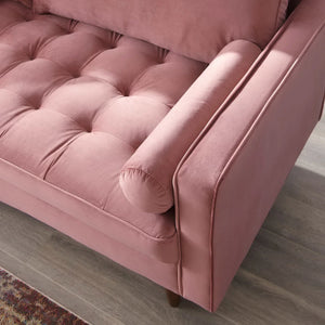 Vaspire Modern Dusty Rose Velvet Performance Sofa Close-up of a pink velvet sofa with tufted cushions on a wooden floor.