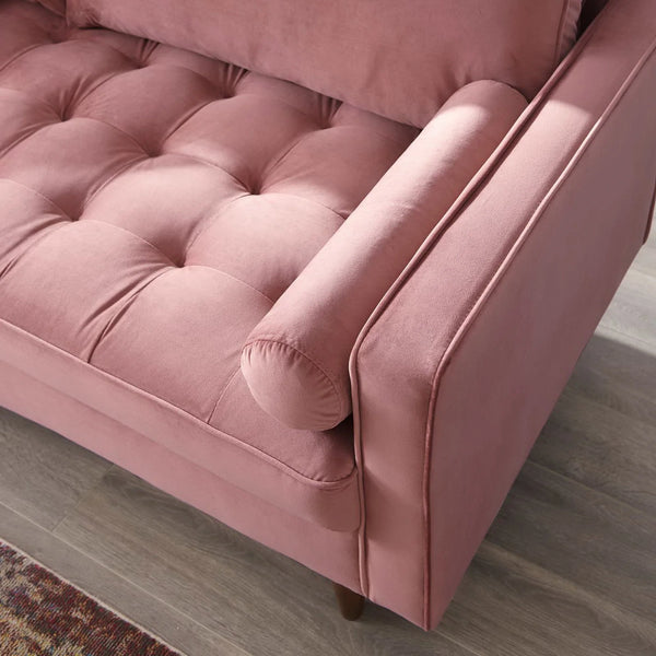 Vaspire Modern Dusty Rose Velvet Performance Sofa Close-up of a pink velvet sofa with tufted cushions on a wooden floor.