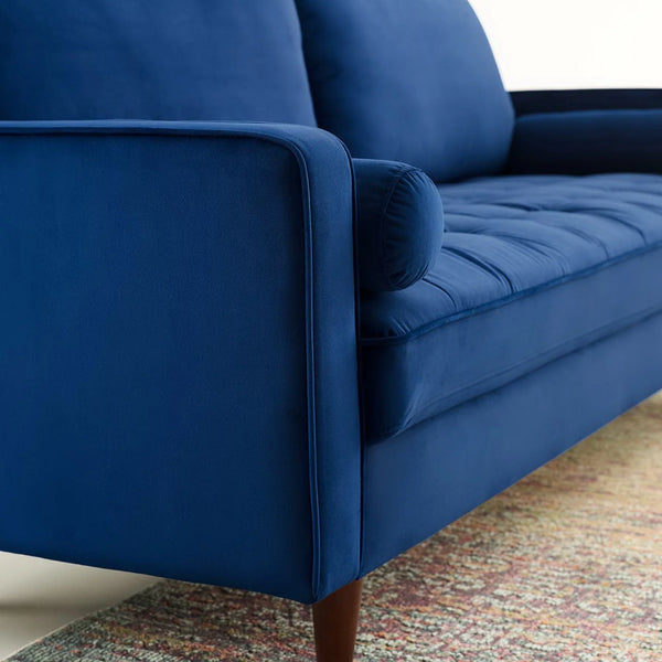 Vaspire Modern Navy Velvet Performance Sofa Close-up of a blue sofa with wooden legs on a patterned rug.