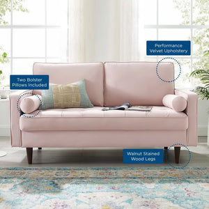 Vaspire Modern Pink Velvet Performance Loveseat Pink sofa with bolster pillows and wooden legs in a room with large windows and plants.