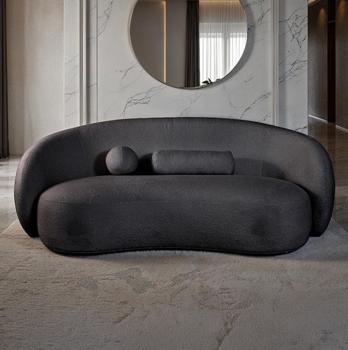 Vika Sofa Curved Back and Arm Black Modern gray sofa in a stylish room with marble walls and a round mirror.