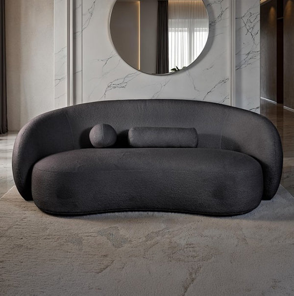 Vika Sofa Curved Back and Arm Black Modern gray sofa in a stylish room with marble walls and a round mirror.