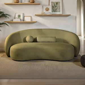 Vika Sofa Curved Back and Arm Olive Green Modern olive green sofa in a living room with shelves and decor.