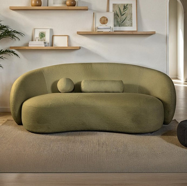 Vika Sofa Curved Back and Arm Olive Green Modern olive green sofa in a living room with shelves and decor.