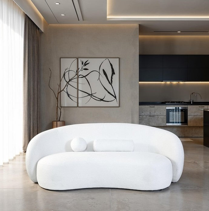 Vika Curved Back and Arm White Chenille Sofa Modern white sofa in a living room setting with a kitchen in the background.